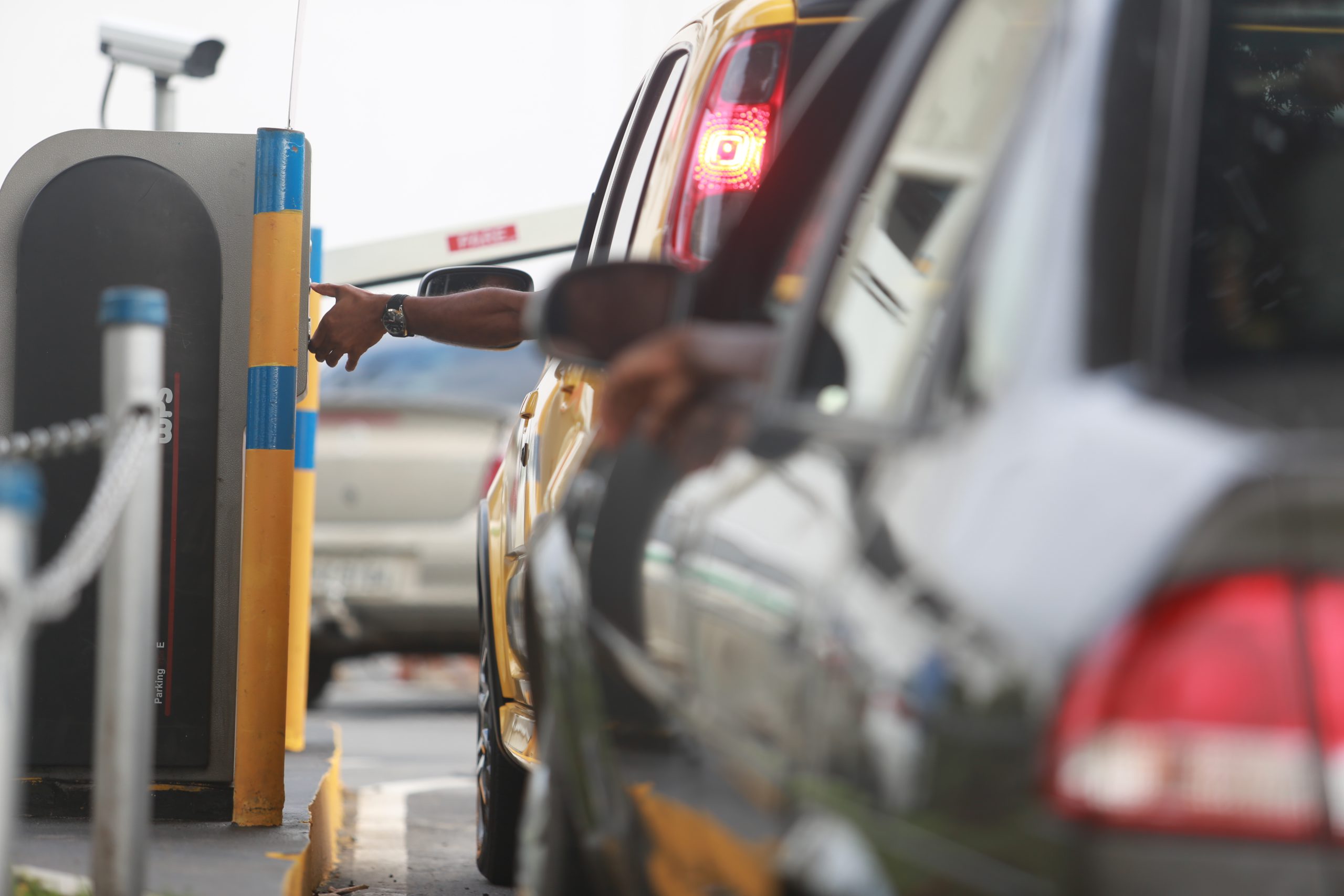 Operador realizando cobrança em estacionamento sem cancela, com motorista pagando no local e opção de usar a tag ConectCar para facilitar o pagamento.